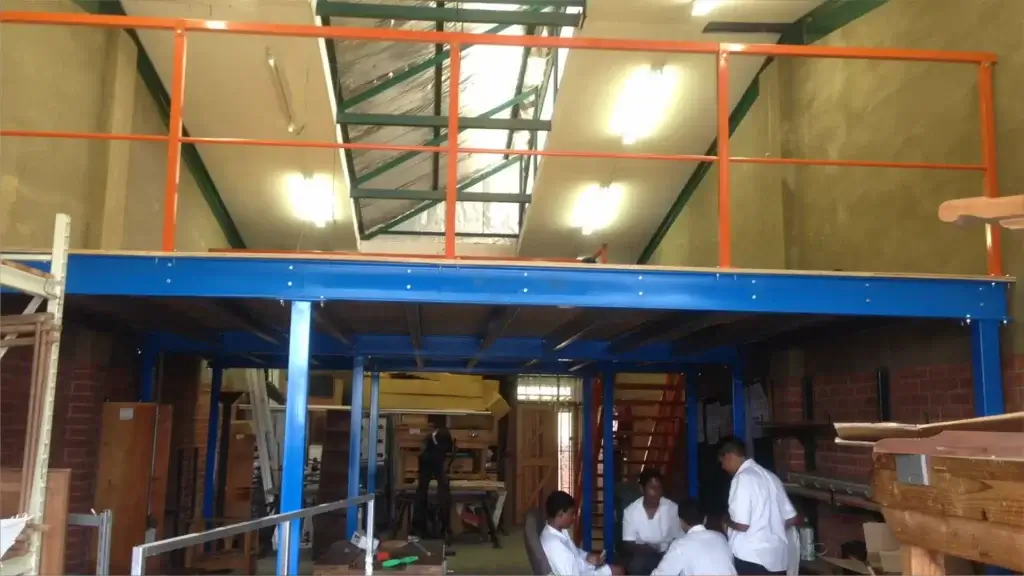 Warehouse mezzanine floor with workers underneath. Used to improve industrial racking and shelving